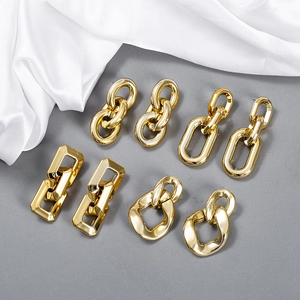 Set mit vier goldenen klobigen Kettenohrringen mit polierter Oberfläche auf Seide