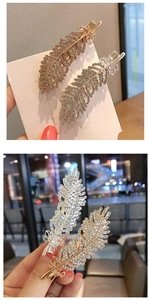 Close-up of gold and silver feather hairpins with sparkling rhinestones set
