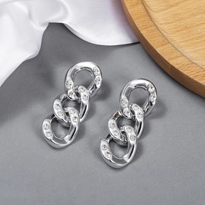 Macro view of interlocking silver-tone chain earrings with sparkling inlaid rhinestones