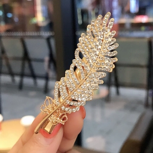 Elegant gold feather hair clip with sparkling rhinestones and a metal duckbill clasp