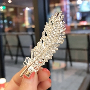 Elegant feather hair clip with silver base and sparkling rhinestones for women