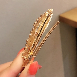 Elegant gold feather hair clip with intricate textures for Korean style hair styling