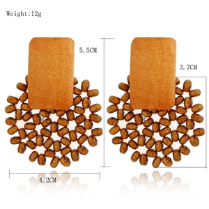 Détail de boucles d'oreilles géométriques en bois faites main avec perles et mesures