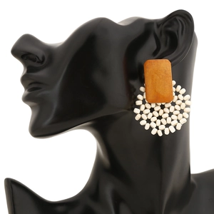 Détail de boucles d'oreilles géométriques en perles faites main sur présentoir noir