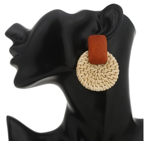 Detail of bohemian rattan earrings with geometric wood pieces on a model display