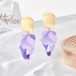 Detail of purple petal earrings with gold matte metal top on white silk fabric