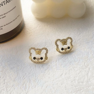 Detailed close-up of tiger-shaped stud earrings with gold plating and sparkling crystals