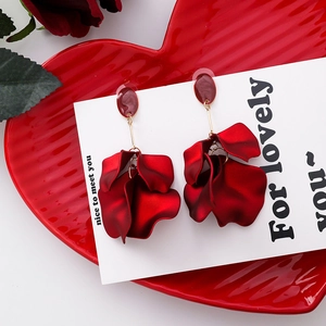 Macro shot of red rose petal drop earrings with elegant matte texture and bead detail