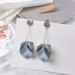 Detail of matte blue layered petal drop earrings with gold tone stems and pebble studs