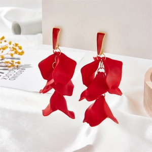 Detail of red petal long tassel earrings with matte finish on a white silk background