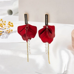 Detail of red petal earrings with matte finish, tassels, and sparkling crystal accents