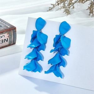 Detail of vibrant royal blue layered petal drop earrings on a white display card