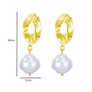 Detailed view of baroque pearl earrings in gold finish with unique textured metal design