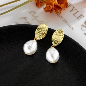 Baroque irregular pearl earrings with vintage gold embossed metal on black tray