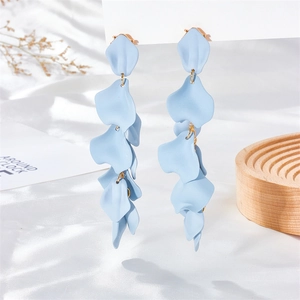 Detailed view of matte light blue petal drop earrings on white silk and wooden display