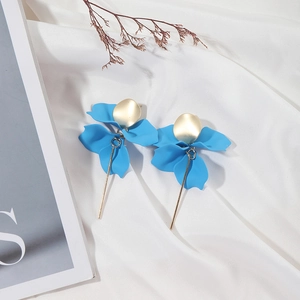 Detail of matte sky blue flower drop earrings with golden accents on white silk