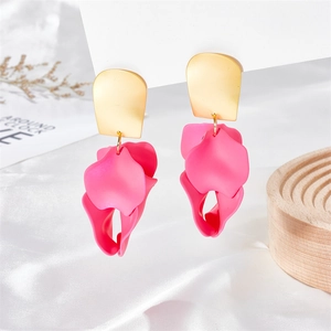 Detail of rose red petal drop earrings with matte gold studs on a wooden stand