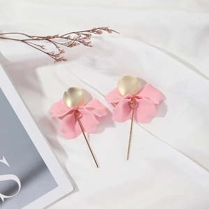 Detail shot of elegant pink petal earrings with gold metallic stems on white silk fabric