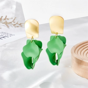 Detail of green petal earrings with matte finish on silk fabric with elegant props