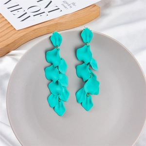Detail of matte teal petal tassel earrings cascading on a ceramic tray for a chic look
