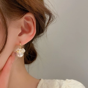 French style flower pearl drop earrings with gold finish on model for elegant woman