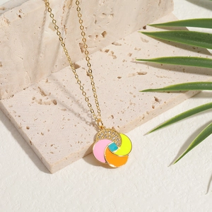 Minimalist gold necklace with colorful pinwheel pendant on textured stone base