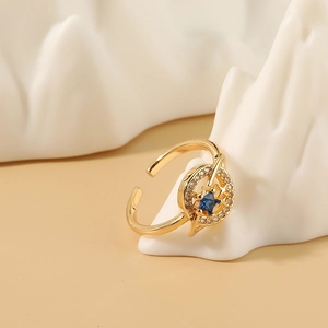 Anillo de planeta dorado ajustable con gema estrella azul y órbitas celestiales