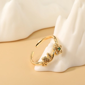 Anillo ajustable de flores doradas con gema verde y cristales blancos brillantes