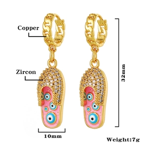 Macro-opname van koperen oorbellen met roze slipper hanger en zirkonia duivels oog