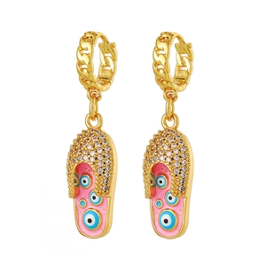 Detail van gouden slipper oorbellen met witte zirkoon pavé en roze boze oog emaille