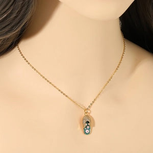 Collana dorata con ciondolo a pantofola di cristalli indossata da una modella