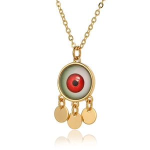 Detailed close-up of gold geometric evil eye pendant with red iris and three dangling charms
