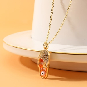 Collana con ciondolo a infradito dorato e occhio del diavolo su tazza di porcellana