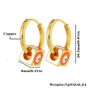 Detail view of golden hoop earrings with square evil eye charms in copper material