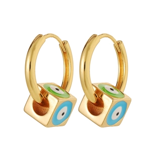 Detail of square gold earrings with enamel evil eye patterns on a white background
