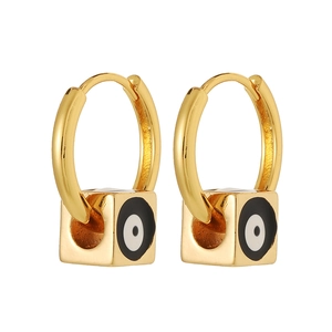 Macro view of gold hoop earrings featuring square evil eye charms and polished finish