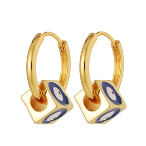 Detail of square gold evil eye charms on round hoop earrings with blue enamel