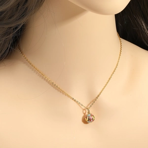Détail du pendentif sphère œil grec en émail coloré sur chaîne dorée porté par mannequin