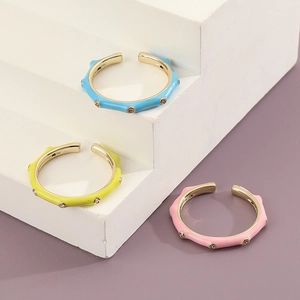 Drei farbenfrohe Emaille-Wellenringe in Blau, Gelb und Rosa mit funkelnden Zirkonia-Steinen