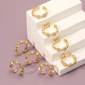 Adjustable golden evil eye rings with hexagon zircon accents on a modern display
