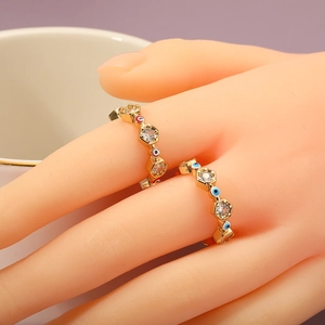 Detailed view of evil eye rings with blue and red zircon on a model's hand