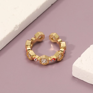 Macro view of gold evil eye ring with cubic zirconia and enamel on purple background