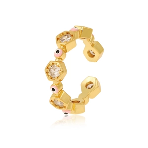 Detail of gold evil eye ear cuff with pink resin and sparkling zircon hexagons