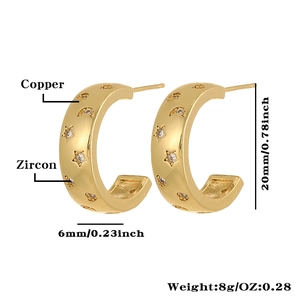 Detalle de pendientes de aro dorados con circonitas, estrellas y luna, de 20x6mm