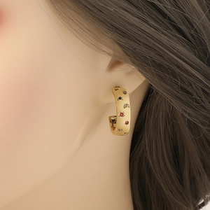 Elegantes pendientes en forma de C bañados en oro con motivos de estrellas y lunas