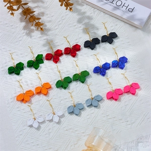 Minimalist multi-colored flower petal drop earrings with gold hooks on white fabric