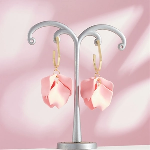 Close-up of pink petal pendant earrings with gold hooks and frosted matte texture