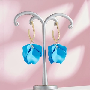 Detailed close-up of sky blue layered petal earrings with gold geometric hooks