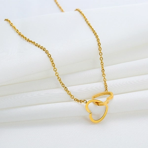 Elegant gold double interlocking heart necklace on white satin background for women