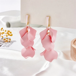 Close-up of pink matte petal drop earrings with layered floral design on a silk background
